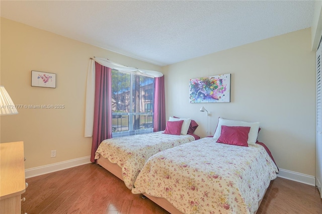 bedroom with wood-type flooring and a textured ceiling