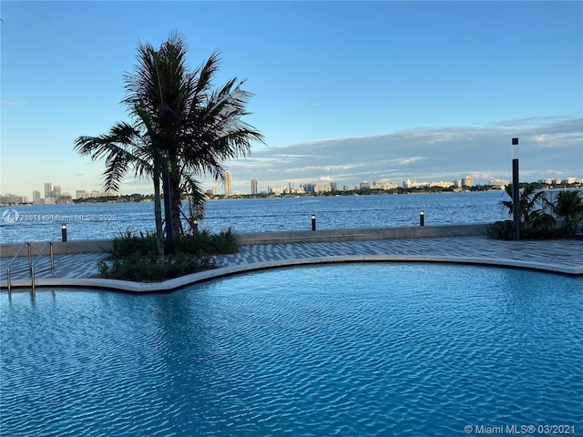 view of swimming pool featuring a water view