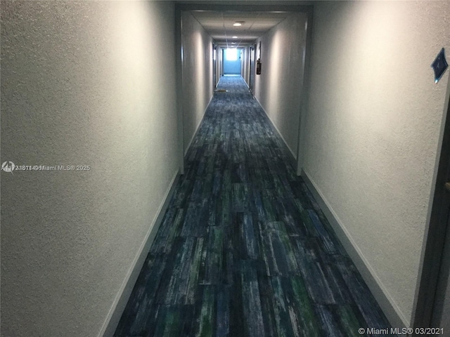 corridor with dark hardwood / wood-style flooring