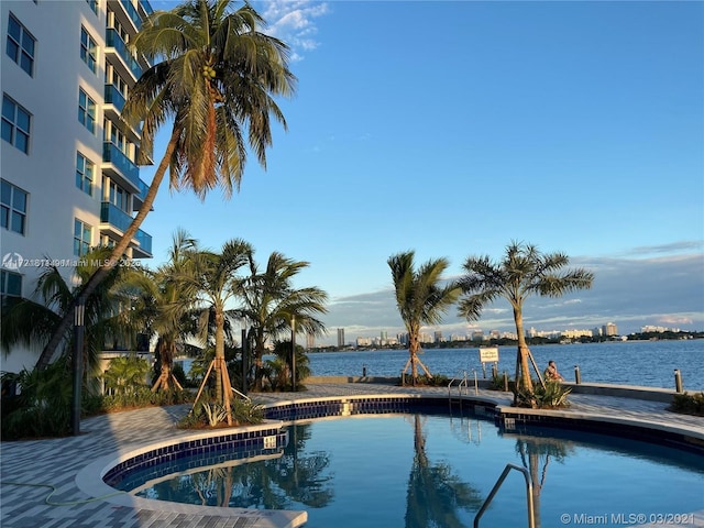 view of swimming pool featuring a water view