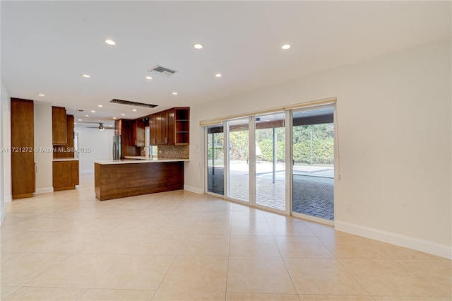 kitchen with ceiling fan, kitchen peninsula, stainless steel fridge, decorative backsplash, and light tile patterned flooring