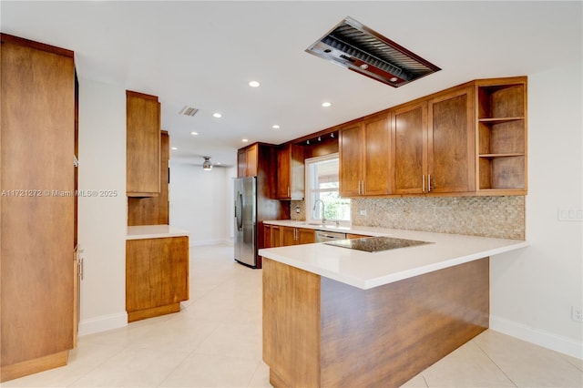 kitchen featuring sink, decorative backsplash, light tile patterned floors, kitchen peninsula, and stainless steel appliances