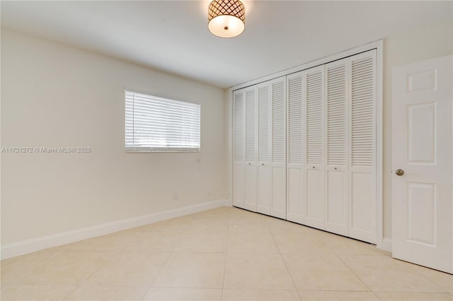 unfurnished bedroom featuring light tile patterned floors and a closet