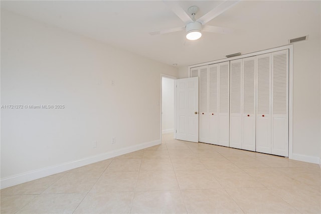 unfurnished bedroom with ceiling fan, a closet, and light tile patterned floors