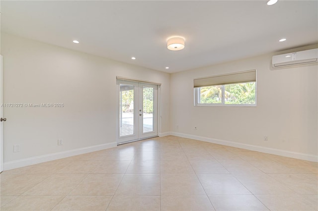 tiled empty room with a wall mounted air conditioner, french doors, and a healthy amount of sunlight