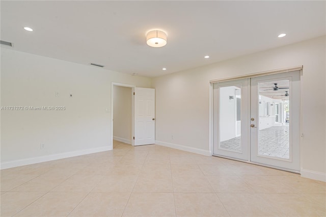 tiled spare room featuring french doors