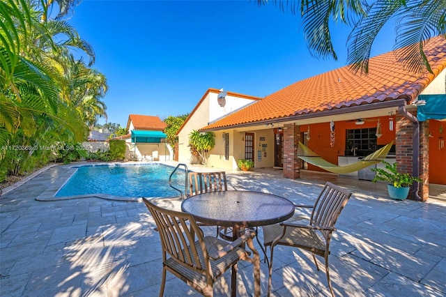 view of swimming pool featuring ceiling fan and a patio