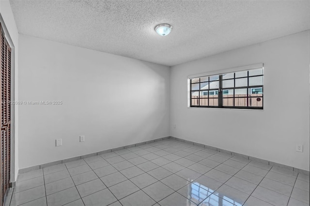 tiled spare room with a textured ceiling