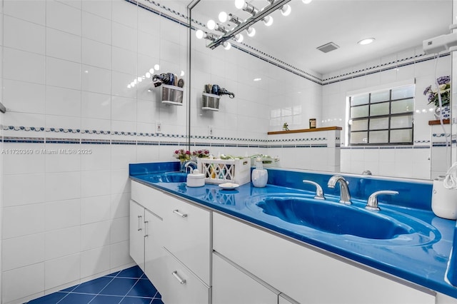 bathroom with tile patterned floors, vanity, and tile walls