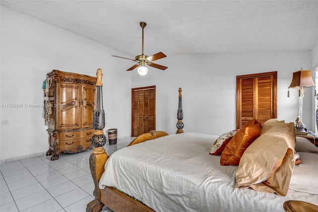 tiled bedroom featuring a textured ceiling, ceiling fan, and vaulted ceiling