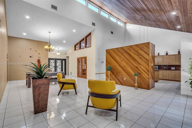 living room with french doors, a towering ceiling, wood ceiling, light tile patterned floors, and a notable chandelier