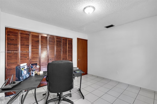 tiled office space with a textured ceiling