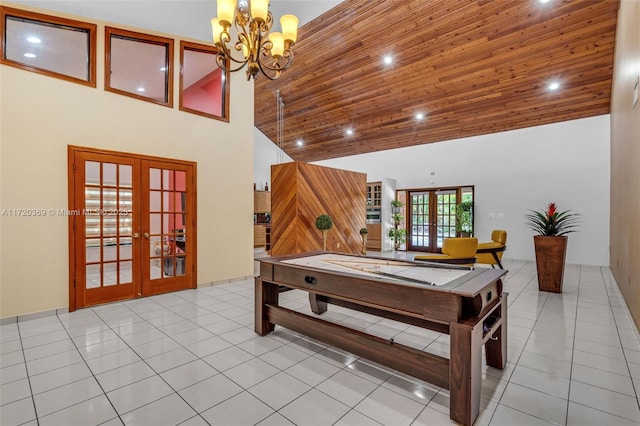 rec room with wooden ceiling, a high ceiling, an inviting chandelier, french doors, and light tile patterned flooring