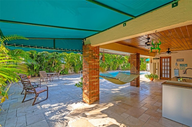 view of patio with ceiling fan and sink