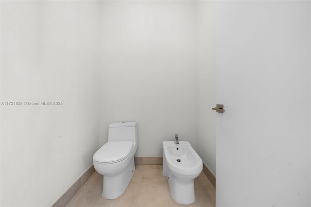 bathroom with tile patterned flooring, a bidet, and toilet