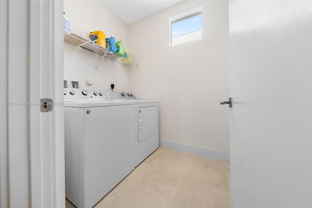 laundry area with washing machine and dryer and light tile patterned floors