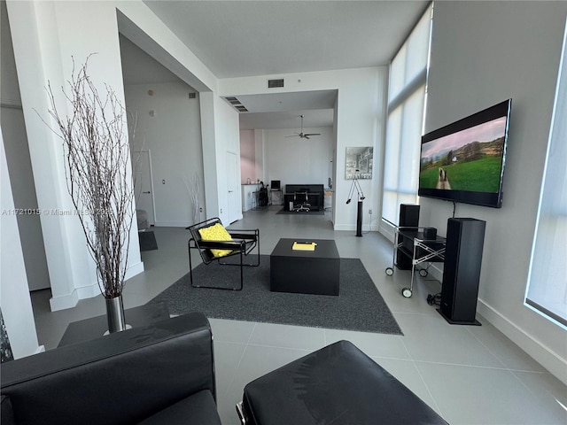 living room with light tile patterned floors, plenty of natural light, and ceiling fan