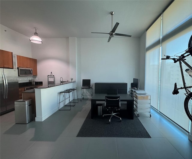 office space with a high ceiling and ceiling fan