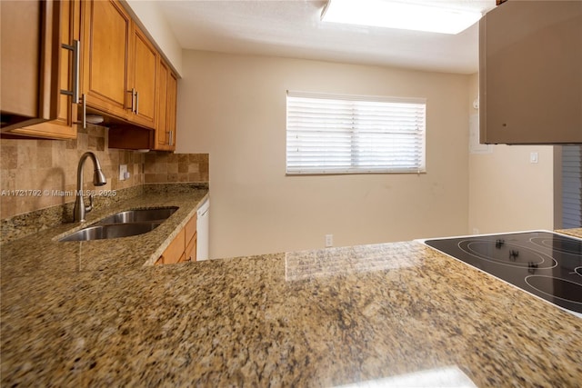 kitchen with dishwasher, light stone countertops, sink, and tasteful backsplash