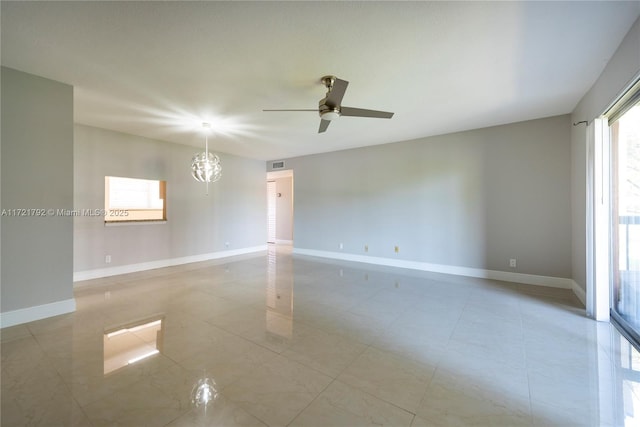 unfurnished room with ceiling fan with notable chandelier