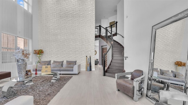 living room featuring a high ceiling and light wood-type flooring