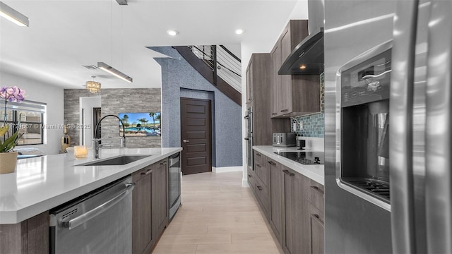 kitchen with stainless steel dishwasher, black electric cooktop, sink, decorative light fixtures, and wine cooler