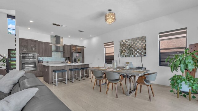 dining room with a wealth of natural light and light hardwood / wood-style floors