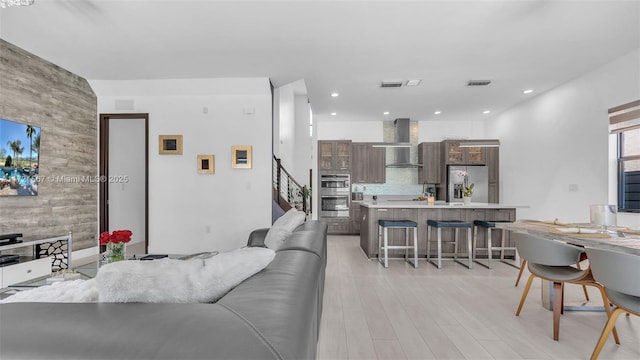 living room featuring wood walls and light hardwood / wood-style flooring