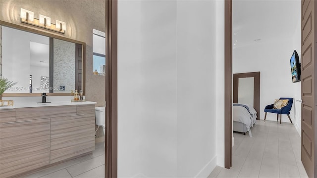 bathroom with tile patterned flooring, vanity, and toilet