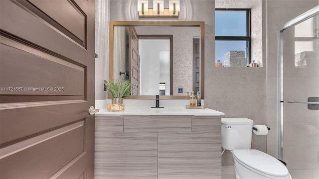 bathroom featuring vanity, toilet, and a shower with shower door