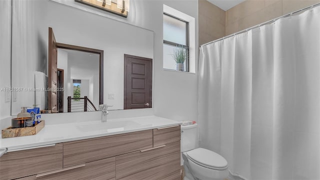 bathroom featuring a shower with shower curtain, vanity, and toilet