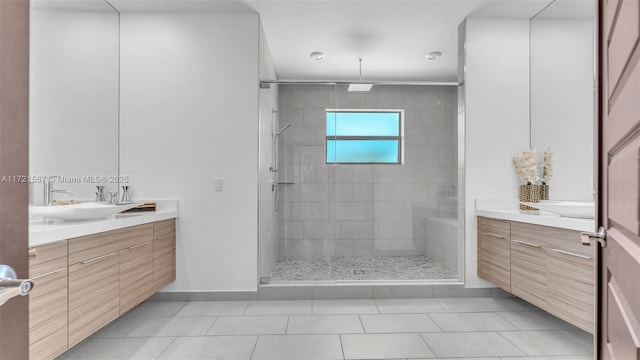 bathroom featuring a tile shower, vanity, and tile patterned floors