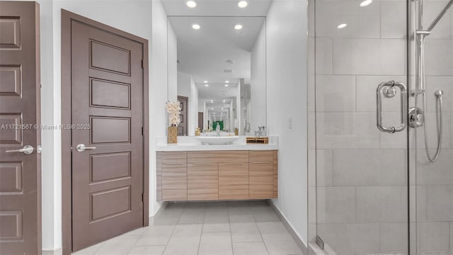 bathroom featuring tile patterned floors, a shower with door, and vanity