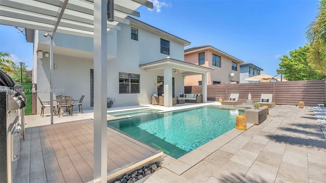 view of pool with a wooden deck, a patio area, and an outdoor hangout area