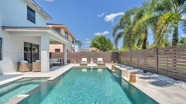 view of pool featuring an outdoor living space, an in ground hot tub, and a patio