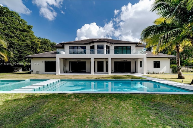 back of house with a lawn, a balcony, and a patio area