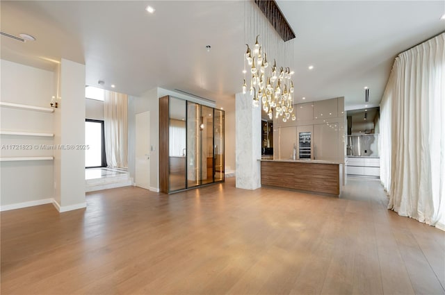 unfurnished living room featuring light hardwood / wood-style floors and a notable chandelier