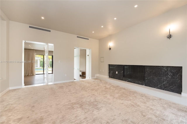 unfurnished living room featuring a premium fireplace and carpet