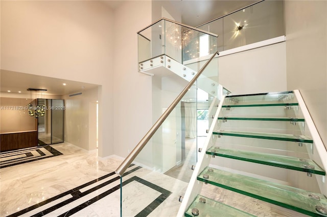 staircase featuring a towering ceiling