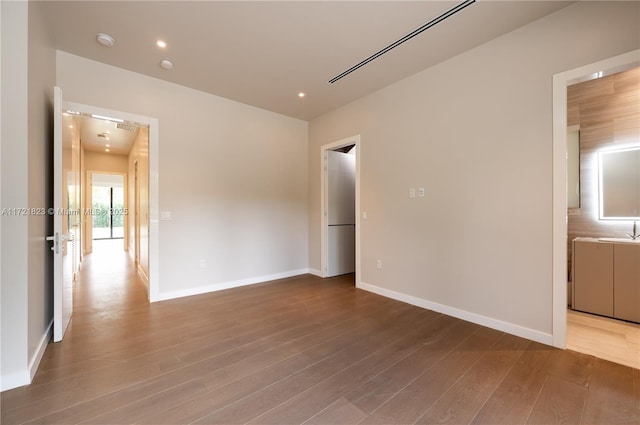 unfurnished bedroom with sink and wood-type flooring