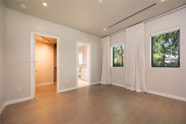 unfurnished bedroom featuring connected bathroom and light hardwood / wood-style flooring