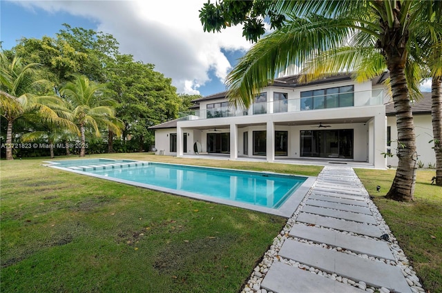 view of pool featuring ceiling fan, a patio area, and a lawn