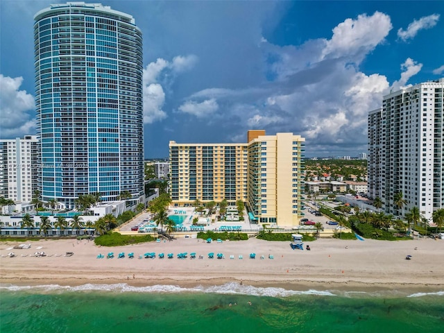 view of property with a water view and a beach view