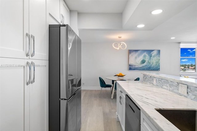 kitchen featuring sink, stainless steel appliances, light stone counters, light hardwood / wood-style flooring, and white cabinets