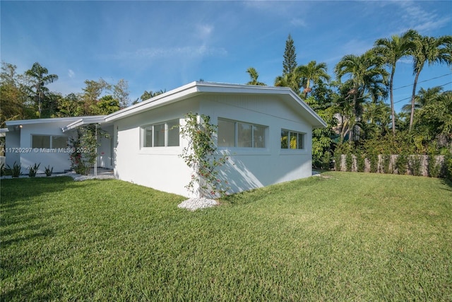 view of property exterior with a lawn and stucco siding