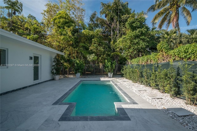 view of swimming pool featuring a patio area, fence, and a fenced in pool