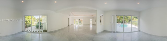 hall featuring a healthy amount of sunlight, marble finish floor, baseboards, and recessed lighting