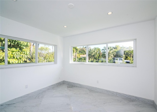 empty room with recessed lighting and marble finish floor