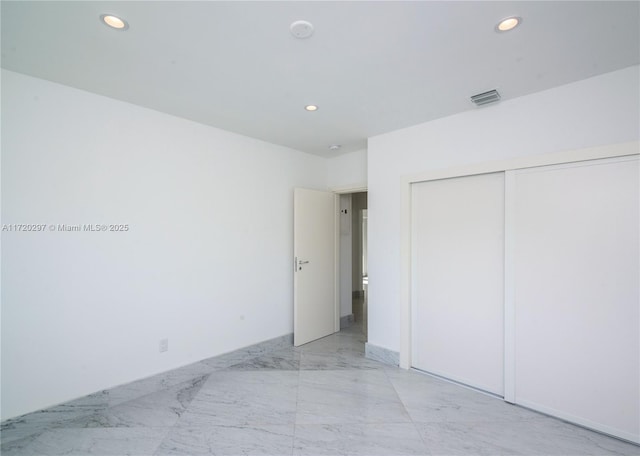 unfurnished bedroom with marble finish floor, visible vents, a closet, and recessed lighting