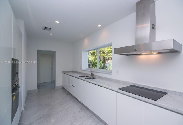 kitchen featuring visible vents, modern cabinets, black appliances, a sink, and exhaust hood